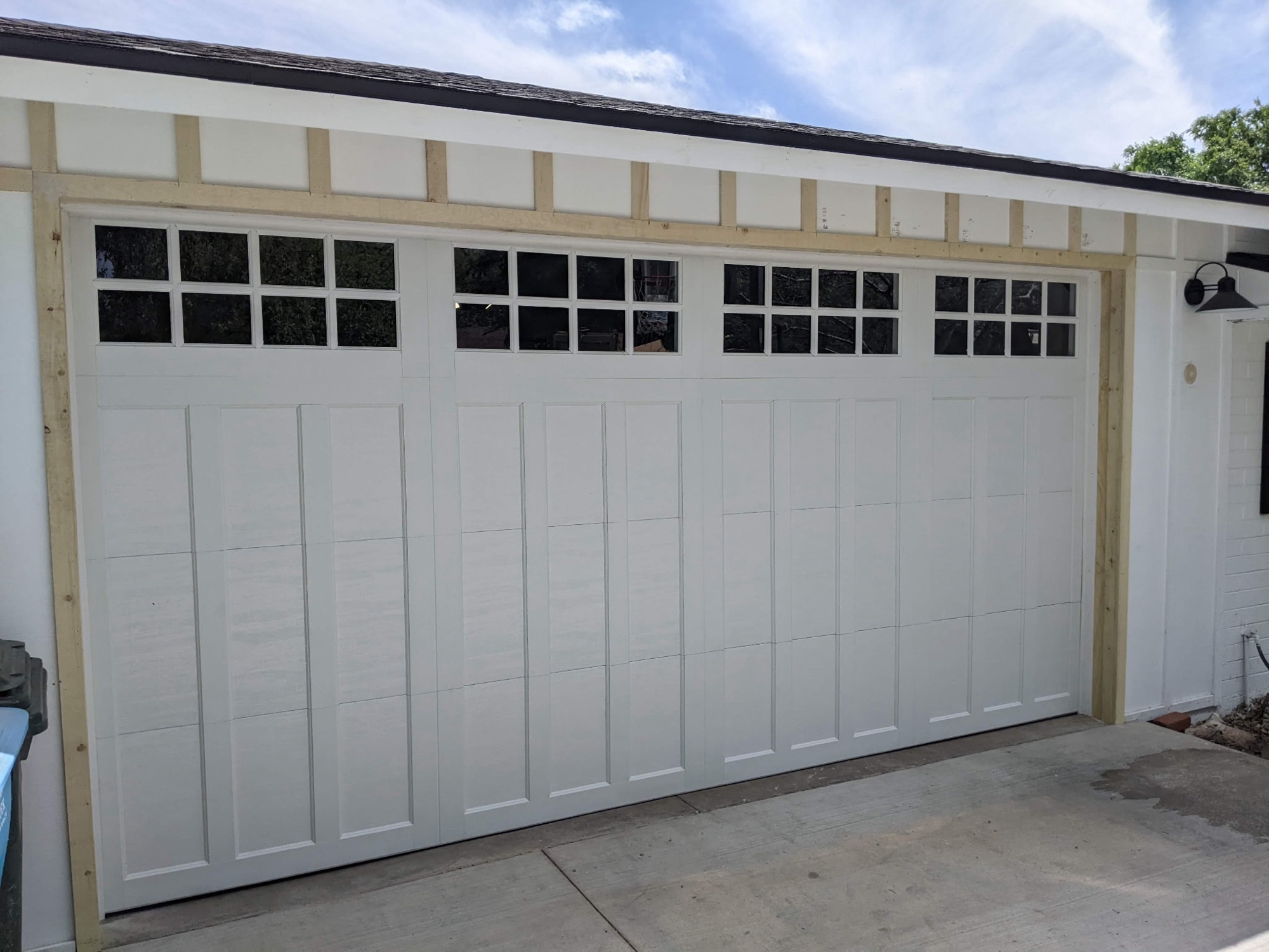 White craftsman carriage-style door with grid window inserts