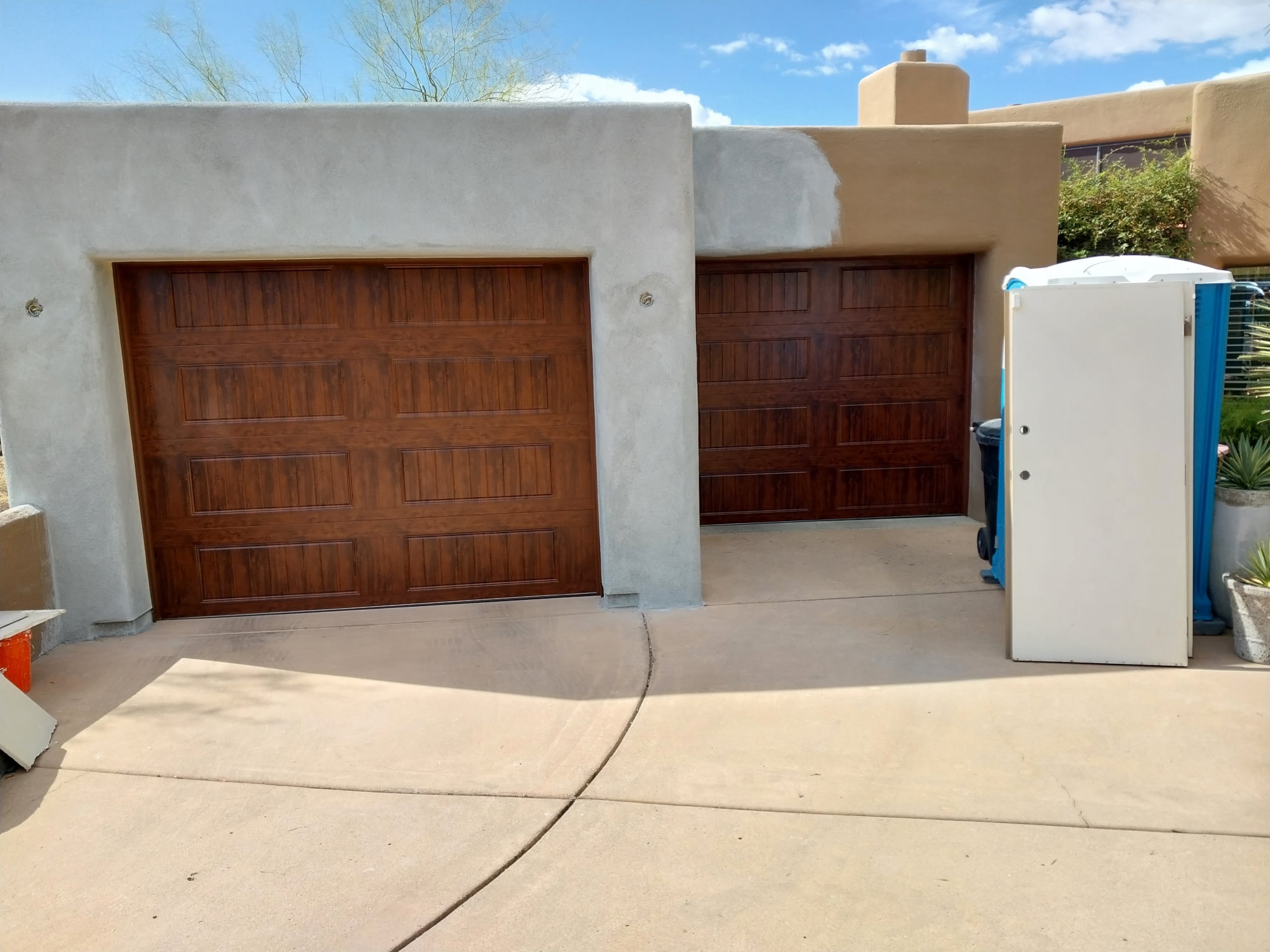 Dark walnut wood-look doors on Southwestern adobe home