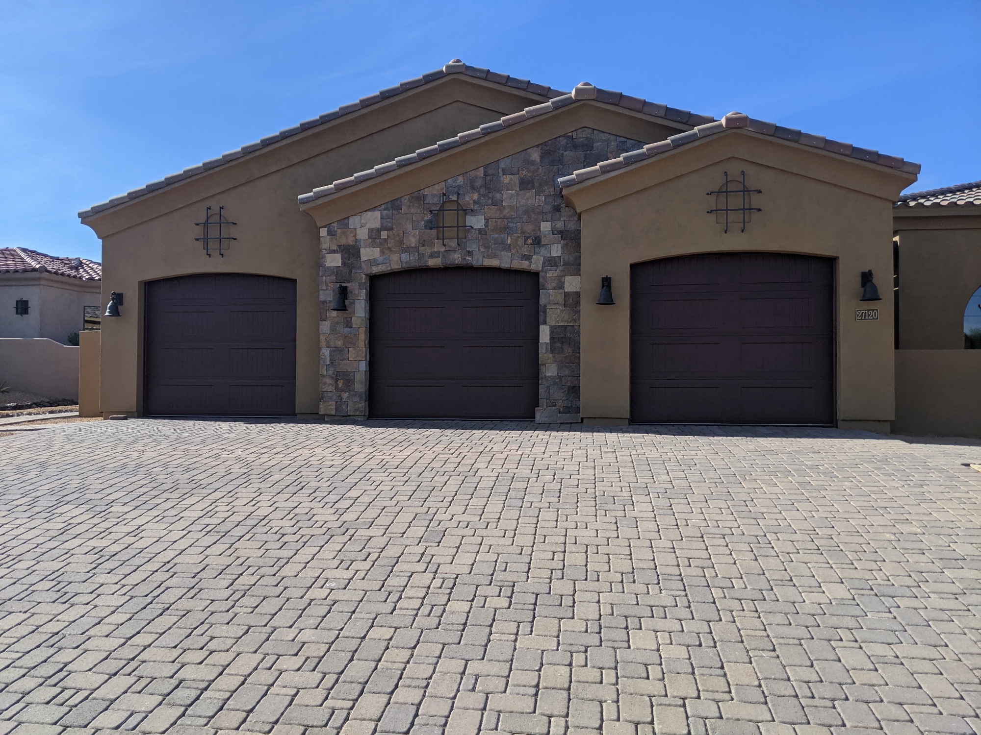 Three-car garage with custom dark panel doors on Arizona estate home